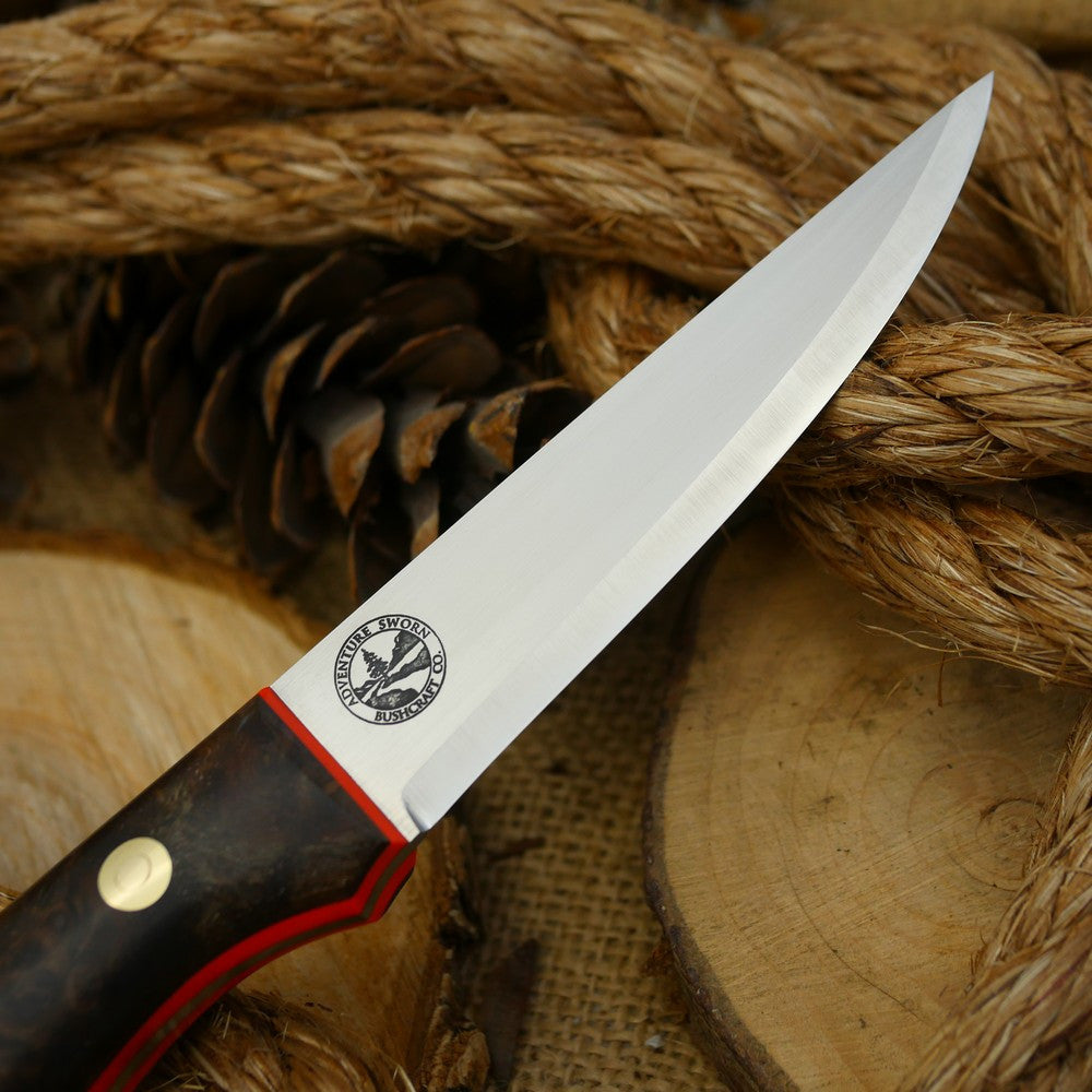 A Voyageur bushcraft knife with stabilized maple burl and hunter orange g10 liners.