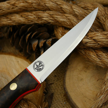 A Voyageur bushcraft knife with stabilized maple burl and hunter orange g10 liners.